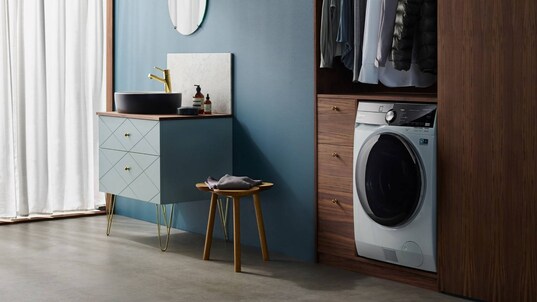Ένα στεγνωτήριο ρούχων της Electrolux τοποθετημένο σε μια ντουλάπα κάτω από ένα ράφι ρούχων.