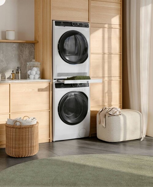 Στεγνωτήριο Electrolux και πλυντήριο ρούχων στοιβαγμένα το ένα πάνω στο άλλο σε ένα ηλιόλουστο δωμάτιο.