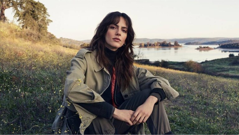 Γυναίκα που κάθεται στο γρασίδι στη φύση.